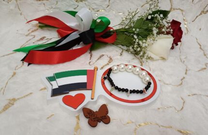 Handgemaakte armband van zwarte kralen, witte grote parels en kleine stervormige vlaggetjes in een bijzonder design.