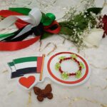 Handgemaakte armband van rode kralen en bloemvormige groene kralen in bijzonder design.