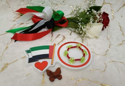 Handgemaakte armband van rode kralen en bloemvormige groene kralen in bijzonder design.