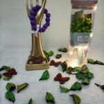 Handgemaakte armband van paarse houten kralen en wit lint.